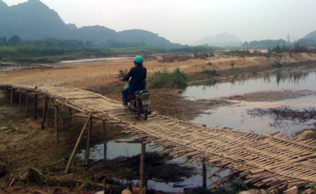Một[-]phần[-]cầu[-]bằng[-]tre[-]được[-]nối[-]từ[-]bờ[-]qua[-]khu[-]vực[-]bãi[-]đất[-]cát[-]lớn.