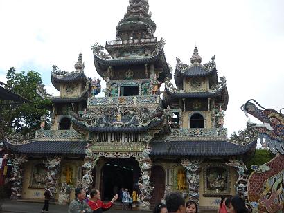 Dọc[-]hai[-]bên[-]chính[-]điện[-]là[-]hai[-]hàng[-]cột[-]rồng[-]khảm[-]mảnh[-]sành[-]tương[-]tự[-]như[-]phong[-]cách[-]khảm[-]tại[-]các[-]lăng[-]mộ[-]vua[-]nhà[-]Nguyễn.[-]Bên[-]trên[-]hai[-]hàng[-]cột[-]ấy[-]là[-]những[-]bức[-]phù[-]điêu[-]khảm[-]sành[-]mô[-]tả[-]lịch[-]sử[-]Đức[-]Phật[-]Thích[-]Ca[-]từ[-]giáng[-]sinh[-]đến[-]nhập[-]niết[-]bàn.[-]