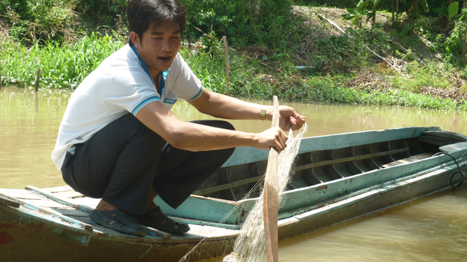 Người[-]dân[-]xã[-]Tân[-]Kiều[-]đi[-]xuồng[-]kéo[-]lưới[-]hi[-]vọng[-]bắt[-]cá[-]dữ[-]nhưng[-]không[-]có[-]kết[-]quả.