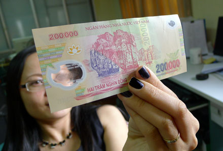 Có[-]thể[-]nhận[-]biết đồng 200.000[-]giả[-]bằng[-]tay[-]và[-]mắt[-]thường.