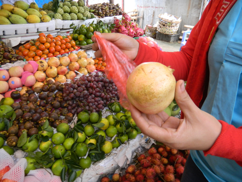 Một[-]người[-]dân[-]đang[-]chọn[-]mua[-]lựu[-]có[-]xuất[-]xứ[-]từ[-]Trung[-]Quốc.